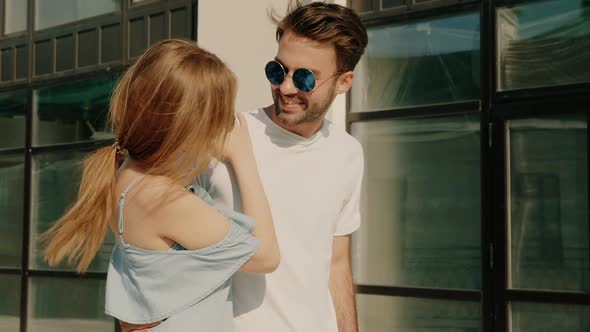 Portrait of smiling beautiful female and her handsome boyfriend posing outdoors