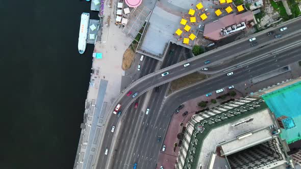 Aerial ascending shot over a highway with traffic in Kiev near the Dnipro river.