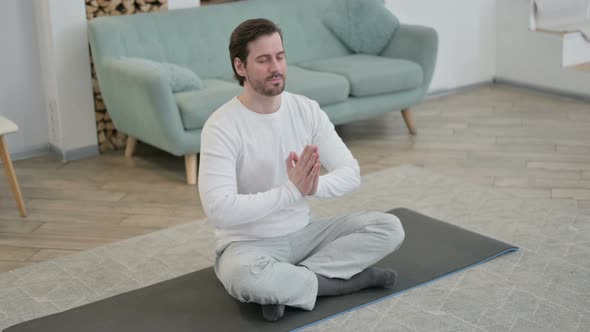 Top View of Young Man Doing Yoga on Yoga Mat at Home