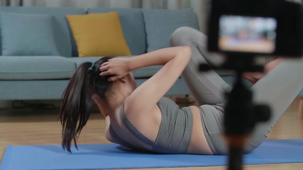 Asian Trainer Female Speaking To Camera And Doing Crisscross Crunch Workout While Recording