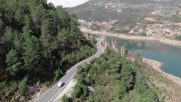 Aerial beautiful view of mountain landscape with cyclist riding on empty road