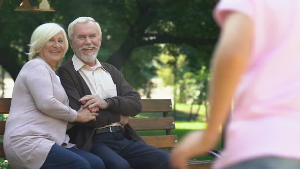 Old Couple Sitting on Bench and Happily Watching Their Grandchildren Having Fun