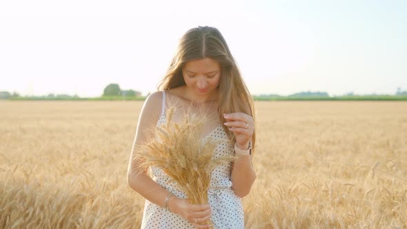 Woman with Long Loose Hair Holds Handmade Wheat Bouquet