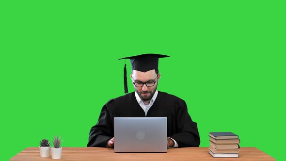 Happy Smiling Male Graduate Student Closes Laptop and Celebrating the End of His Research on a Green