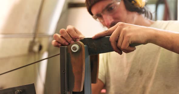 Bladesmith deburring a blade on belt grinder