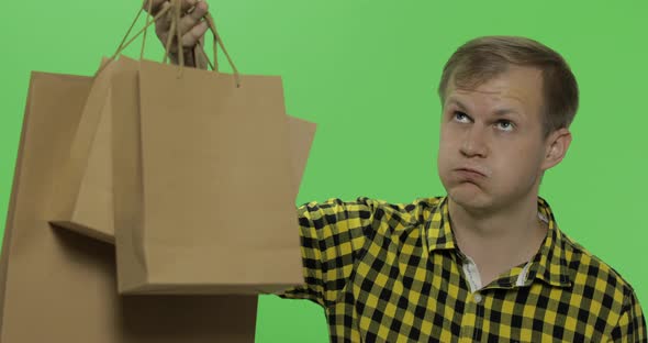 Bored Young Man on Green Screen Chroma Key Background with Shopping Bags
