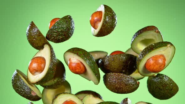 Super Slow Motion Shot of Flying Fresh Avocados on Green Background at 1000 Fps