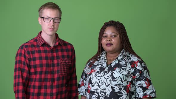 Overweight African Woman and Young Scandinavian Man Together Against Green Background