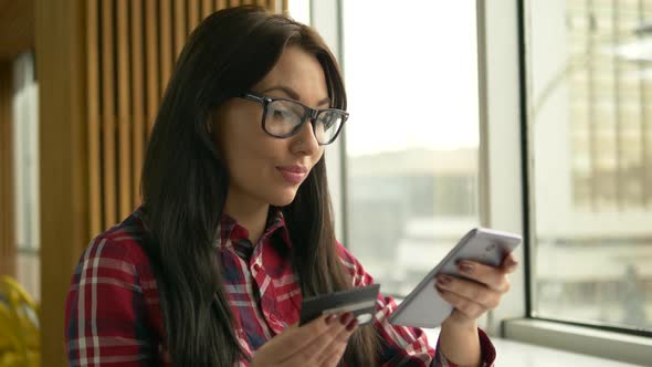 Young Mixed Race Hipster Woman Holding Credit Card and Using Laptop Computer