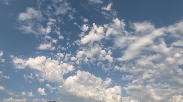 White Clouds Flying On Blue Sky With Sun Rays