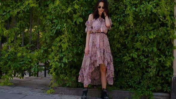 Stylish Hipster Girl Posing Over Green Leaves Bush Background