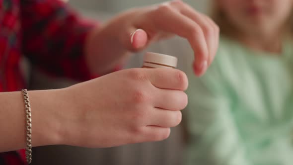 Woman Opens Bottle with Golden Paint Little Girl Sits Nearby