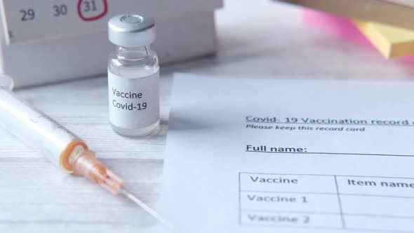 Vaccination Record Card  Hand Sanitizer and Mask on Color Background