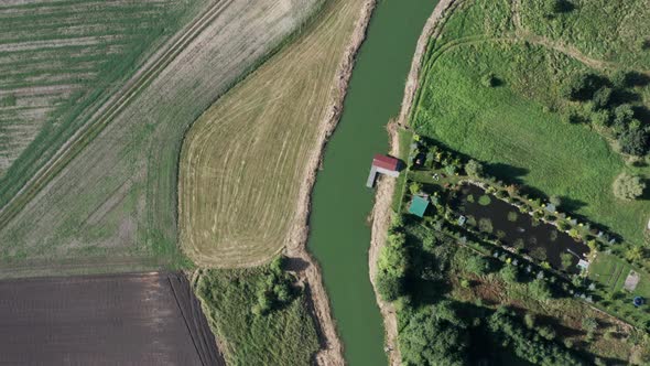 Aerial top down shot of a curvy river among the farms and fields.