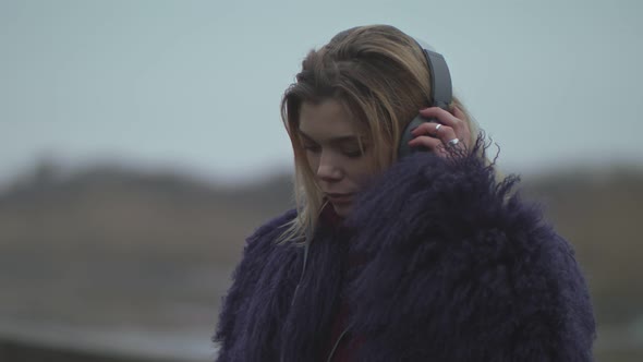 A Young Girl Puts on Headphones and Turns on Music