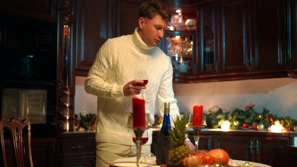 Portrait of Confident Romantic Man Setting Table with Romantic Dinner in Kitchen at Home