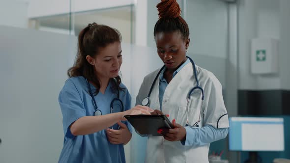 Diverse Medical Team Using Digital Tablet for Information