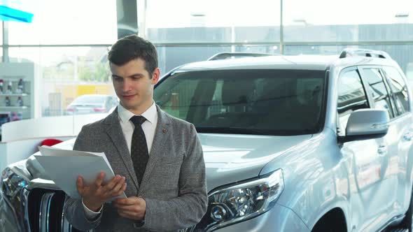 A Happy Buyer Presents a Car From the Automobile Showroom