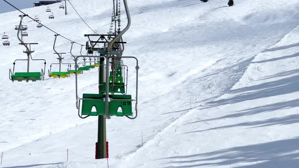 Many Ski Lift Chairs Move on Rope Way at Alpine Winter Resort