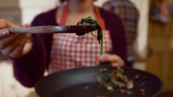 Smiling woman cooking food in kitchen