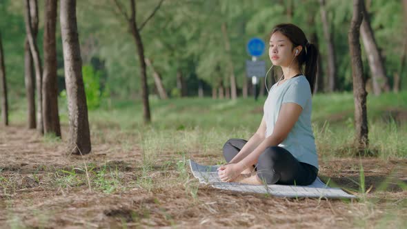 Asian cute girl She is doing yoga in the morning in the garden by the beach.