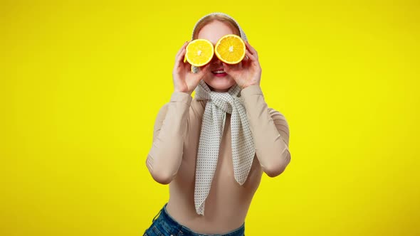 Middle Shot of Joyful Pretty Redhead Woman Closing Eyes with Half Oranges Smiling and Looking at
