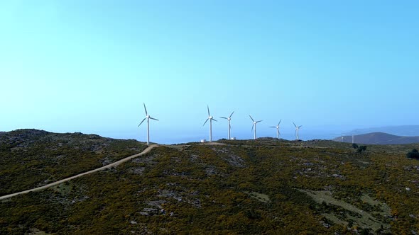 Row Of Fast Spinning Windfarm Turbines In Hillside Of Galicia In Spain. Aerial Dolly Shot