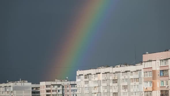 Huge Rainbow in the Cloudy Sky Above the Houses in City