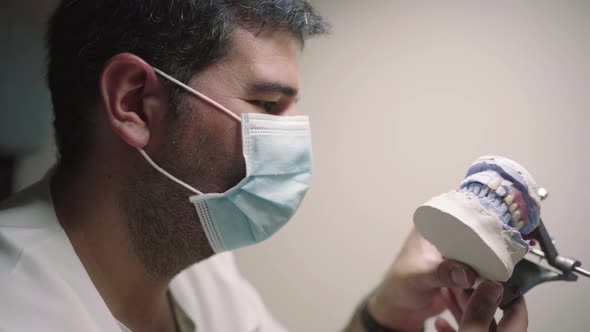 Man in mask with prosthesis in articulator in lab
