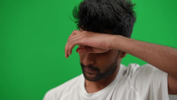 Handsome Middle Eastern Footballer Rubbing Sweat Smiling Looking at Camera Showing Ball on Green