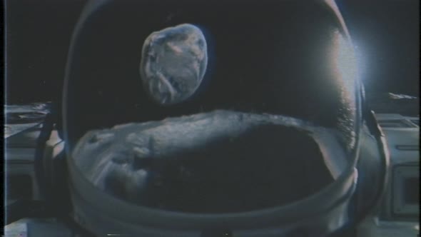 An Astronaut Stands on the Surface of the Moon Among Craters Against the Backdrop of the Planet