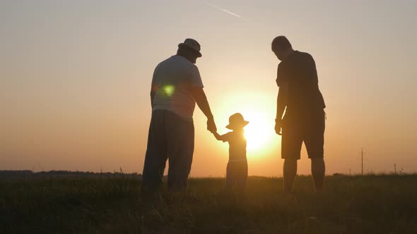 Small Boy with Father and Grandfather at Sunset, Silhouette Concept, Three Generations of a Family