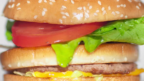 Extreme Closeup Piece of Bread Falling on Finished Appetizing Burger