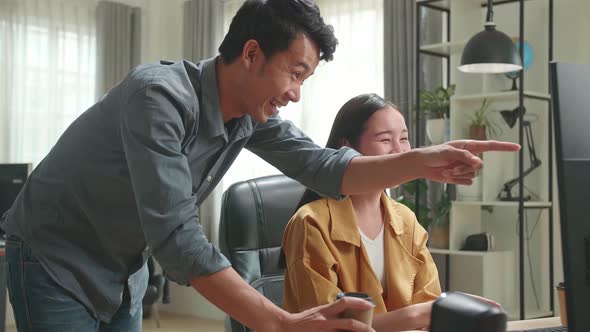 Happy Asian Female Has Discussion With Male While Work On Computer In The Office