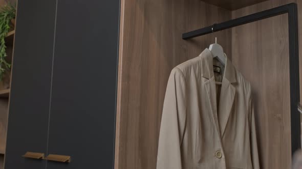 Woman Hanging Jackets in Closet