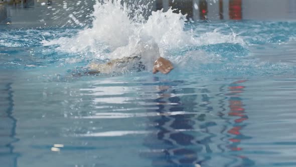 Young Sportsman Swimmer Training in Training Swimming Pool with His Face Being Under the Water