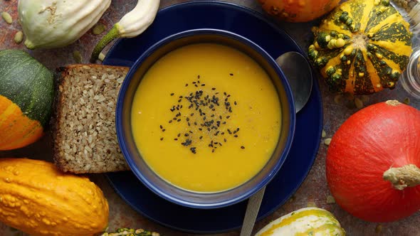 Compositon with Autumn Classic Food. Tasty Homemade Pumpkin Soup Decorated with Black Seed