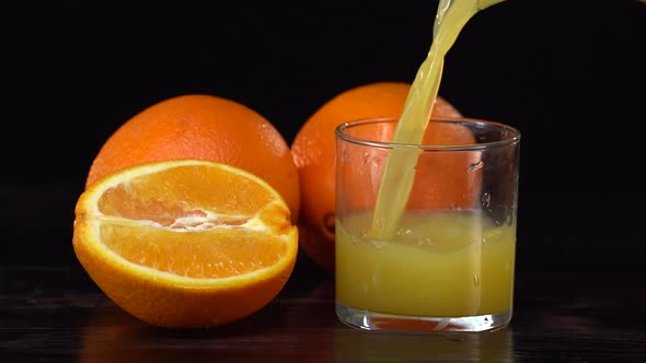 Super Slow Motion Shot of Pouring Fresh Orange Juice Into Glass