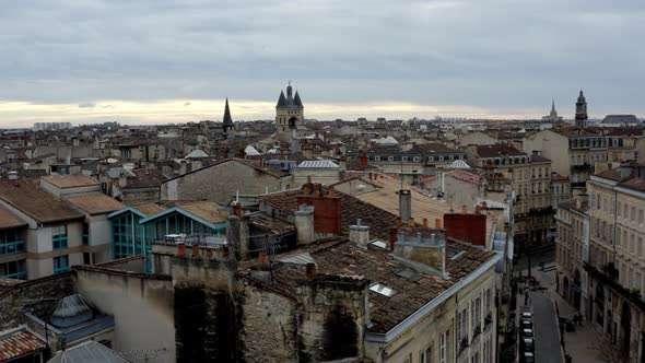 French city of Bordeaux rooftops with Cailhau City Gate and pigeons flying, Aerial pedestal lowering