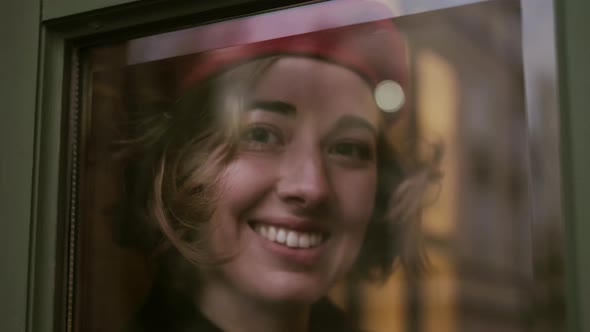 Young Romantic Girl Looking Through The Window Glass.