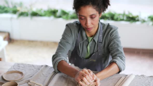 Concentrated woman potter knead clay