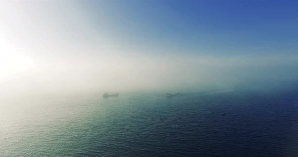 aerial shot of cargo ships in foggy winter day