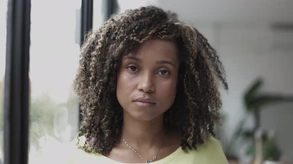 Brazilian Young Woman with Curly Hair Looking at Camera Close to the Window