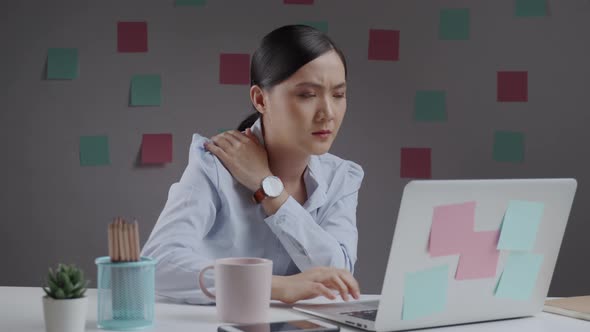 Asian woman working on a laptop was sick with body pain sitting
