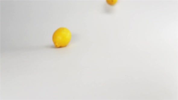 Fresh Yellow Lemons Falling Down on White Surface