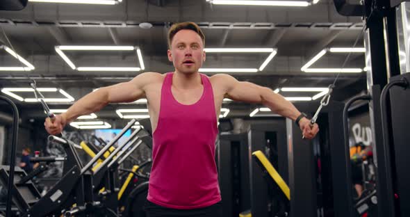 Bodybuilder Doing Exercise On The Simulator In The Gym