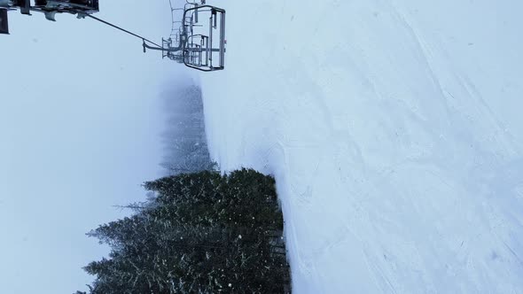 POV Empty Ski Lift Snowy Mountain Winter Forest with Chair Lift At The Ski Resort in Winter