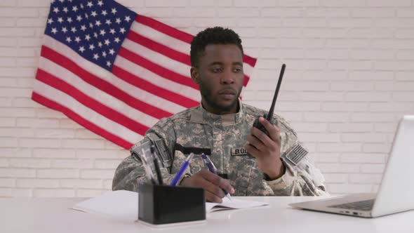 Afro-american Officer Using Radio Transmitter in His Office