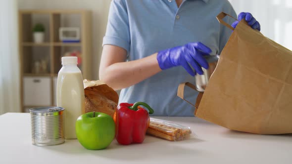 Woman in Gloves Taking Food From Paper Bag at Home