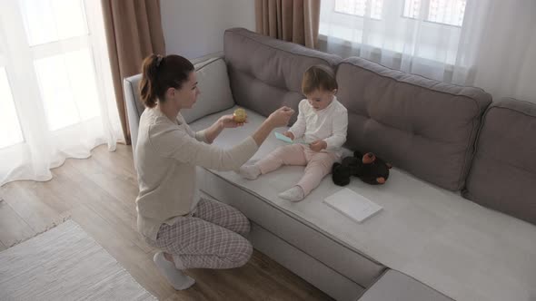 Woman Feeding Child with Spoon